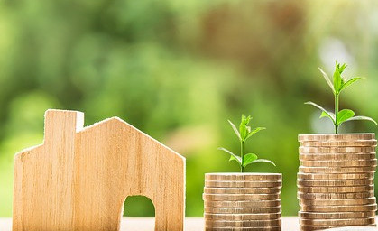 toy wooden house next to coins