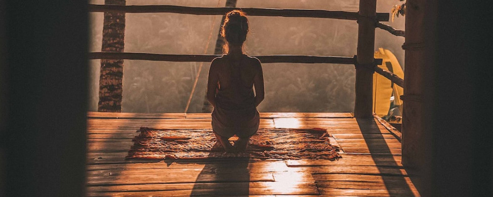 Woman meditating at sunset