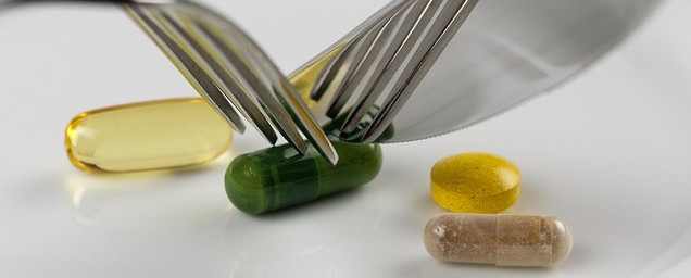 Knife and fork about to cut into a vitamin capsule